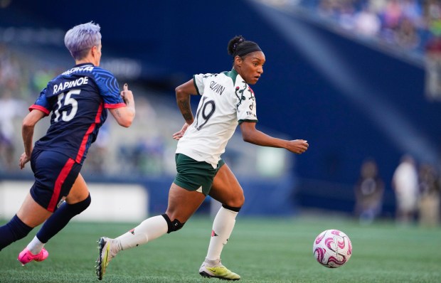 Portland Thorns midfielder Crystal Dunn, #19, moves the ball as OL Reign forward Megan Rapinoe, #15, defends during the first half of an NWSL soccer match on June 3, 2023, in Seattle. (AP Photo/Lindsey Wasson)