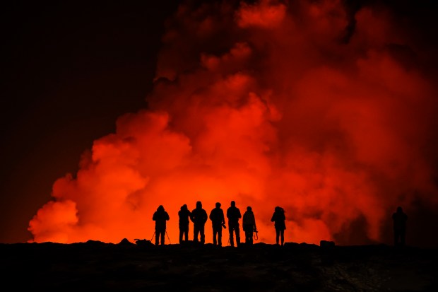 People look at the volcano erupting, north of Grindavík, Iceland, Thursday, Feb. 8, 2024. Iceland's Meteorological Office says a volcano is erupting in the southwestern part of the country, north of a nearby settlement. The eruption of the Sylingarfell volcano began at 6 a.m. local time on Thursday, soon after an intense burst of seismic activity. (AP Photo/Marco Di Marco)