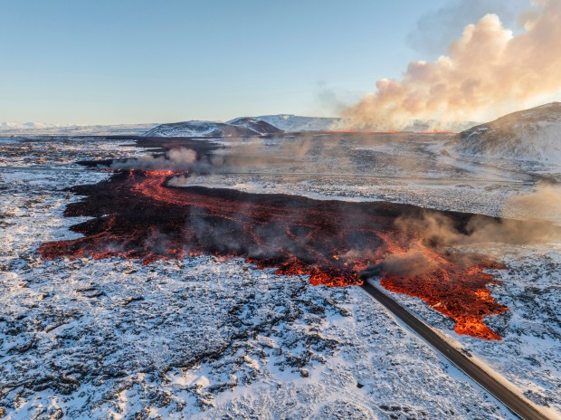 A view of lava crossing the main road to Grindavík and flowing on the road leading to the Blue Lagoon, in Grindavík, Iceland, Thursday, Feb. 8, 2024. A volcano in southwestern Iceland has erupted for the third time since December and sent jets of lava into the sky. The eruption on Thursday morning triggered the evacuation the Blue Lagoon spa which is one of the island nation's biggest tourist attractions. (AP Photo /Marco Di Marco)