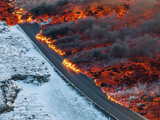 A view of lava crossing the main road to Grindavík and flowing on the road leading to the Blue Lagoon, in Grindavík, Iceland, Thursday, Feb. 8, 2024. A volcano in southwestern Iceland has erupted for the third time since December and sent jets of lava into the sky. The eruption on Thursday morning triggered the evacuation the Blue Lagoon spa which is one of the island nation's biggest tourist attractions. (AP Photo /Marco Di Marco)