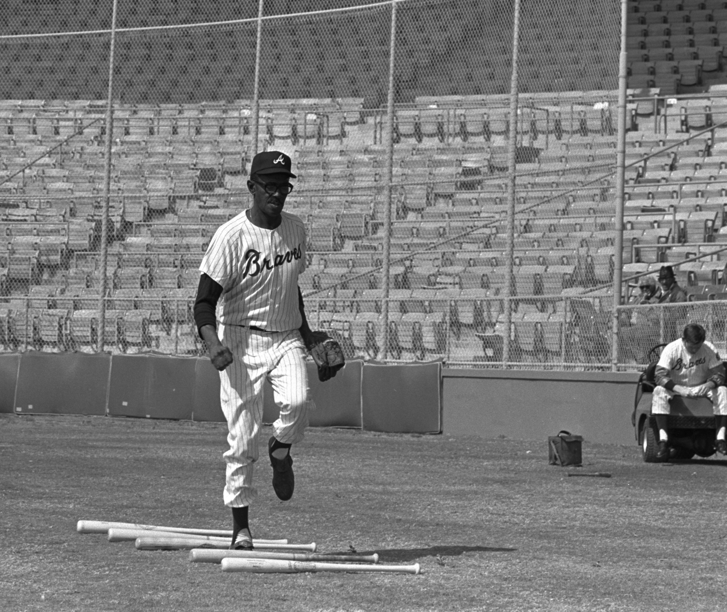 Atlanta Braves assistant trainer Satchel Paige does some exercise hopping over a row of bats during his daily workout at Cleveland's Municipal Stadium on March 9, 1969.
