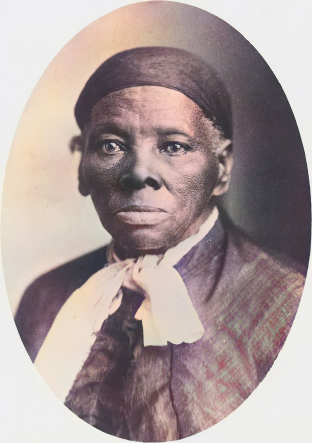 A colorized studio portrait of American abolitionist Harriet Tubman, wearing a necktie, a scarf on her head, and facing the camera with a serious expression, photographed by Tabby Studios in Auburn, New York, 1885. (Gado/Getty Images)