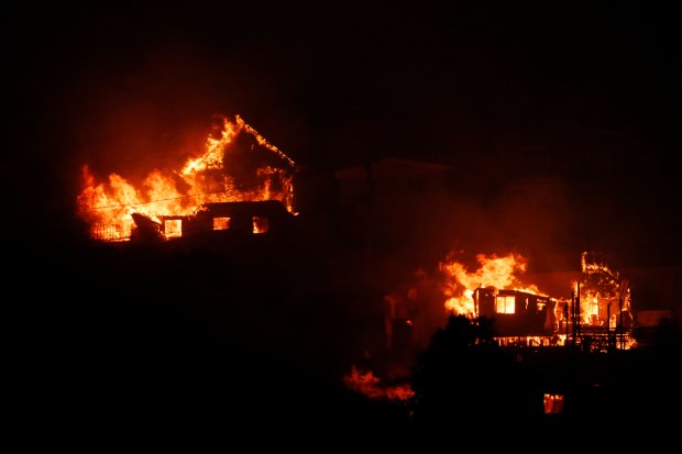 TOPSHOT - Houses burn during a fire in Viña del Mar, Chile on February 3, 2024. The region of Valparaoso and Viña del Mar, in central Chile, woke up on Saturday with a partial curfew to allow the movement of evacuees and the transfer of emergency equipment in the midst of a series of unprecedented fires, authorities reported. (Photo by Javier TORRES / AFP) (Photo by JAVIER TORRES/AFP via Getty Images)