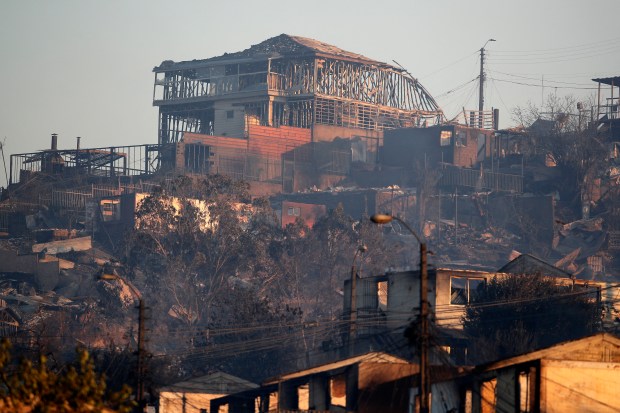 View of burnt houses after a fire that affected the hills in Viña del Mar, Chile on February 3, 2024. The region of Valparaoso and Viña del Mar, in central Chile, woke up on Saturday with a partial curfew to allow the movement of evacuees and the transfer of emergency equipment in the midst of a series of unprecedented fires, authorities reported. (Photo by Javier TORRES / AFP) (Photo by JAVIER TORRES/AFP via Getty Images)
