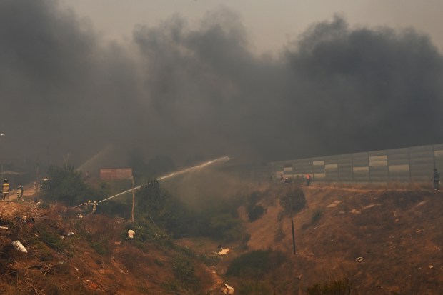 Firefighters work during a forest fire that affected the hills in Quilpue, Viña del Mar, Chile, on February 3, 2024. The region of Valparaoso and Viña del Mar, in central Chile, woke up on Saturday with a partial curfew to allow the movement of evacuees and the transfer of emergency equipment in the midst of a series of unprecedented fires, authorities reported. (Photo by RODRIGO ARANGUA / AFP) (Photo by RODRIGO ARANGUA/AFP via Getty Images)
