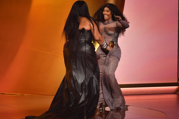 US singer SZA (R) accepts the Best R&B Song award for "Snooze" from US singer Lizzo on stage during the 66th Annual Grammy Awards at the Crypto.com Arena in Los Angeles on February 4, 2024. (Photo by Valerie Macon / AFP) (Photo by VALERIE MACON/AFP via Getty Images)