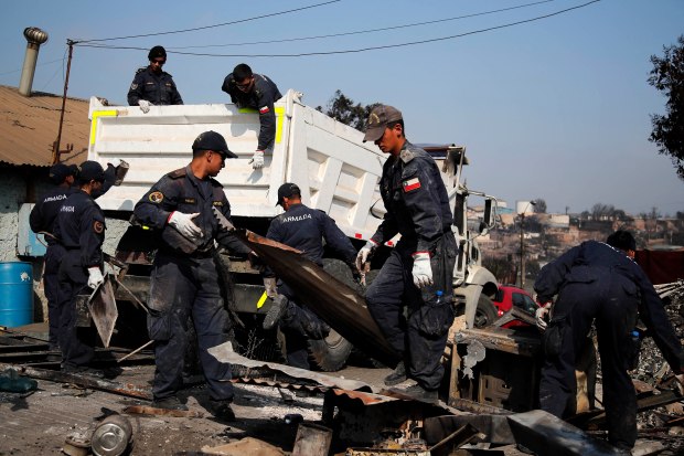 Members of the Chilean Navy remove debris from burned houses after the forest fires in Villa Independencia, Viña del Mar, Chile, on February 5, 2024. The death toll from central Chile's blazing wildfires climbed to at least 112 people on Sunday, after President Gabriel Boric warned the number would rise "significantly" as teams search gutted neighborhoods. (Photo by Javier TORRES / AFP) (Photo by JAVIER TORRES/AFP via Getty Images)