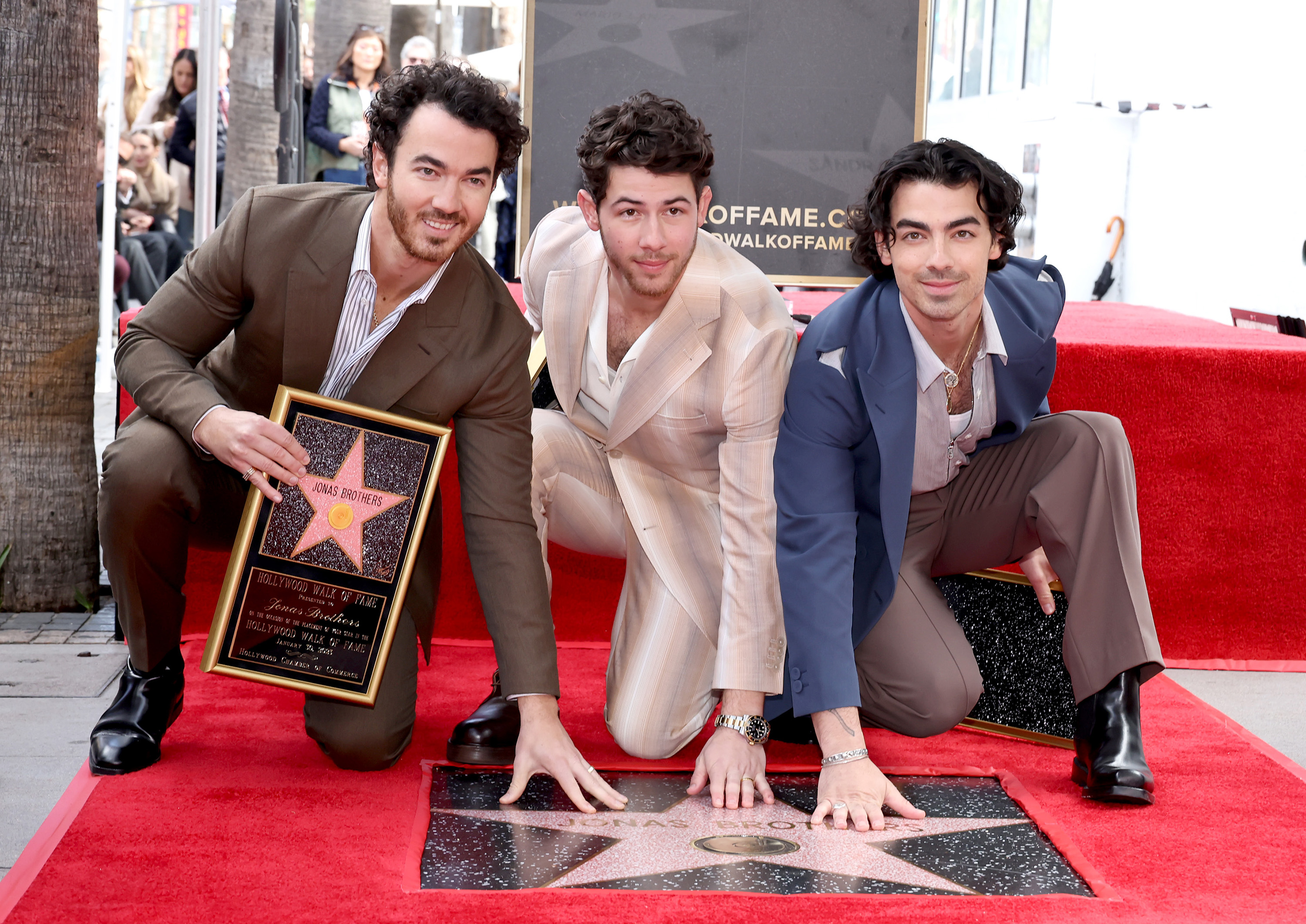 (L-R) Kevin Jonas, Nick Jonas and Joe Jonas of The Jonas Brothers pose with their newly unveiled star on the Hollywood Walk of Fame on Jan. 30, 2023, in Hollywood, Calif.