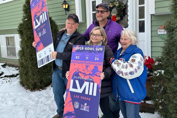 Don Crisman, far left, poses with his wife, Beverley, far right, his daughter Sue Metevier, and her partner Charles Hugo, with posters of Super Bowl 58 tickets, Thursday Jan. 18, 2024, in Kennebunk, Maine. Don Crisman is one of the very few people who has attended every Super Bowl. (AP Photo/David Sharp)